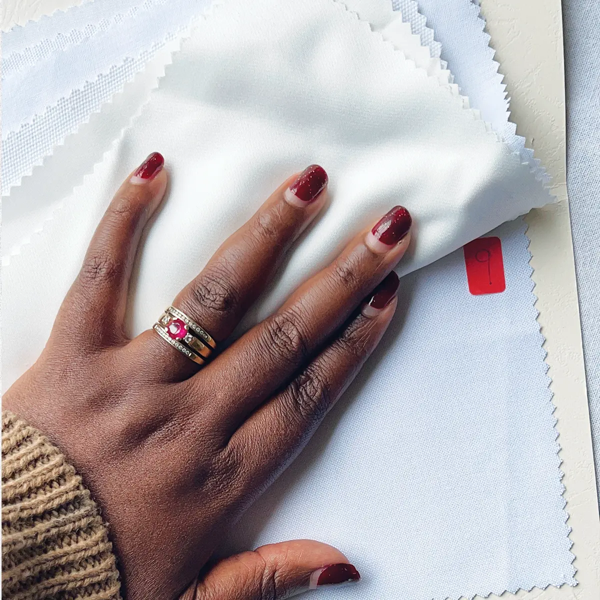 UndaMeta Fabric Swatch Catalogue showing the actual fabric types inside catalogue and numbering, a hand holds them down